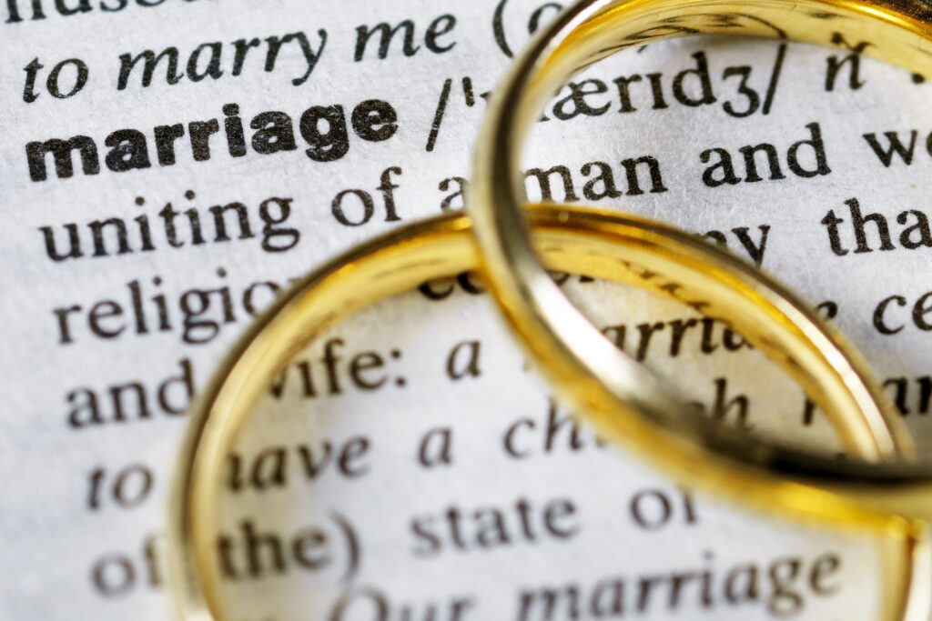 Two wedding rings next to the word "marriage" on a english dictionary woordenboek met twee ringen op het woord 'huwelijk'